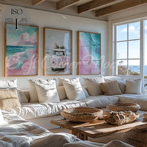 Op de afbeelding: Een woonkamer met een witte hoekbank, een houten salontafel en drie ingelijste prints aan de muur. De prints tonen een roze en blauwe aquarel strandscène, een vintage busje en een roze en blauwe aquarel strandscène. De kamer heeft een groot raam met uitzicht op de zee.