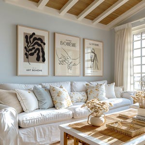 May include: Three framed art prints on a light blue wall. The prints feature abstract line drawings and the text "Art Boh&egrave;me", "Galerie Boh&egrave;me", and "La Femme".