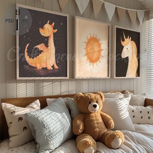 Puede incluir: Tres ilustraciones enmarcadas de un dragón, un sol y un unicornio. El dragón es naranja y tiene un fondo azul claro. El sol es amarillo y tiene un fondo marrón claro. El unicornio es blanco y tiene un fondo azul oscuro. Los marcos son todos blancos y tienen un acabado de madera clara.