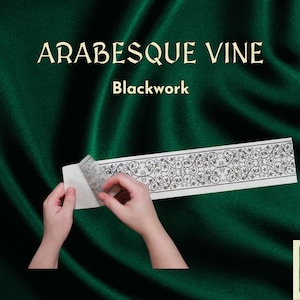 May include: A white sheet of paper with a black and white arabesque vine design. The paper is being peeled off of a backing sheet. The text "ARABESQUE VINE Blackwork" is at the top of the image.
