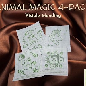 Peut inclure: Quatre motifs de point de croix verts sur papier quadrillé, représentant un chat, une licorne, un écureuil et un motif géométrique. Les motifs sont intitulés "Animal Magic 4-Pack: Visible Mending".