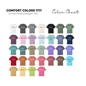 Pode incluir: Carta de cores mostrando 28 cores diferentes de camisetas unissex de peso pesado. As cores est&atilde;o dispostas em linhas e colunas, com os nomes de cada cor impressos abaixo de cada camiseta.