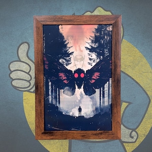 May include: Framed art print featuring a dark forest scene with a large moth-like creature with red eyes. A lone figure stands in the foreground. The frame is a dark brown color.