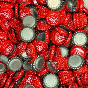 May include: A large pile of red bottle caps with the words "Nuka Cola" printed on them.
