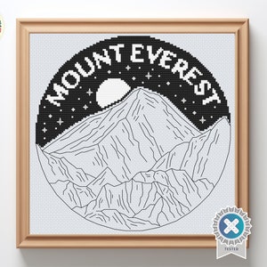 Op de afbeelding: Zwart-witte kruissteekpatroon van de Mount Everest met een maan en sterren op de achtergrond. De tekst "Mount Everest" is in een cirkel rond de berg geschreven.