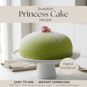 Könnte beinhalten: Ein grüner Prinzessinnenkuchen auf einem weißen Kuchenständer, garniert mit einer rosa Blume und Puderzucker. Das Bild enthält den Text "Swedish Princess Cake recipe" und "Digital Download". Der Kuchen steht auf einem weißen Tisch mit einem beigen Tuch.