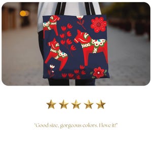 May include: A navy blue tote bag with a repeating pattern of red and white Dala horses and floral designs.