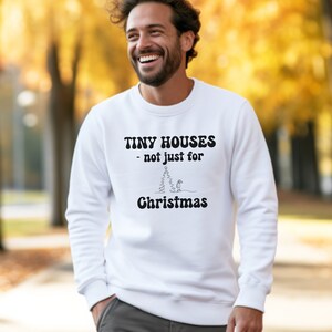 May include: White sweatshirt with a black graphic that says "Tiny Houses - not just for Christmas" with a simple line drawing of a tiny house in a snowy forest.