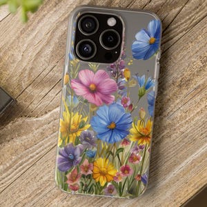 May include: A clear phone case with a floral design. The flowers are pink, blue, yellow, and white. The case is designed for a phone with a triple camera lens.
