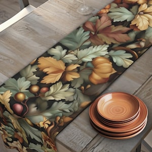 May include: A rectangular table runner with a floral and leaf pattern in shades of green, yellow, and brown. The runner is placed on a wooden table set for a meal, with plates, glasses, and a bowl of oranges.