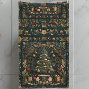 May include: A decorative Christmas-themed towel with a dark teal background. The towel features a detailed design of a Christmas tree, ornaments, gifts, and other festive elements. The design is framed by ornate floral patterns.