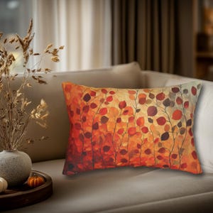 May include: A rectangular throw pillow featuring a vibrant autumn-inspired pattern of stylized leaves in shades of red, orange, and yellow. The design depicts thin, dark branches extending upward, covered in dense, overlapping foliage across the surface.