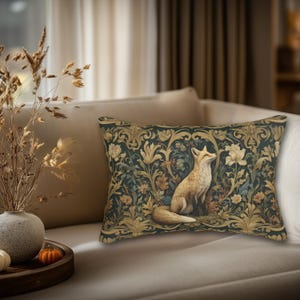 May include: A rectangular throw pillow featuring a central illustration of a fox sitting among intricate gold and cream-colored floral patterns set against a dark, muted green background. The design includes scrolling leaves and stylized blossoms.