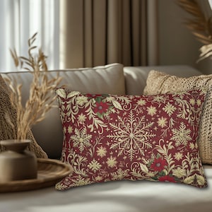 May include: A rectangular throw cushion featuring a deep red background with a repeating pattern of gold-coloured snowflakes, swirling botanical vines, and red poinsettia flowers with green leaves. The design covers the entire front surface.