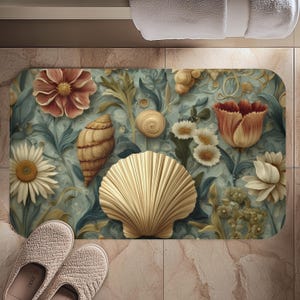 May include: A rectangular bath mat with a detailed floral and seashell design in gold, red, and white against a teal background. The mat features a large scallop shell and various flowers. A pair of beige slippers are in the foreground.