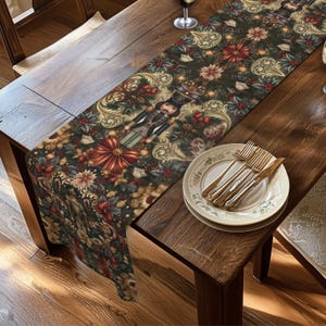 May include: A rectangular table runner featuring a dark green background with a repeating pattern of nutcrackers, red poinsettias, holly berries, and gold scrollwork. The runner is laid out on a wooden table with a stack of white plates and gold cutlery.