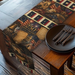 May include: A patriotic table runner featuring a collage of American flags, historical documents, and military imagery. The runner includes the text "250th Anniversary 1776-2026". A black plate with four forks rests on a wooden table.