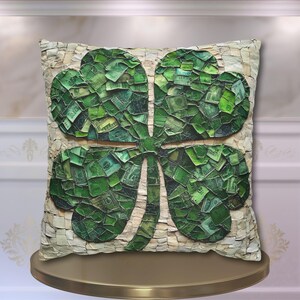 May include: A decorative pillow with a four-leaf clover design made of green mosaic tiles. The clover is made of small pieces of green fabric, resembling money.