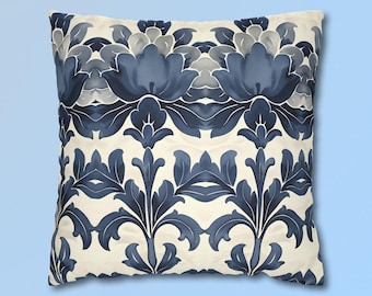 May include: A square throw pillow featuring a symmetrical, repeating floral pattern in shades of navy blue, slate blue, and light gray against a cream-colored background. The design consists of stylized, mirrored leaf and petal motifs.