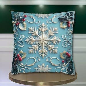 May include: A square decorative pillow with a light blue background and a raised, ornate design. The design features a large, central snowflake, holly leaves, and red berries. The pillow is displayed on a gold-colored stand, suggesting a holiday or winter theme.