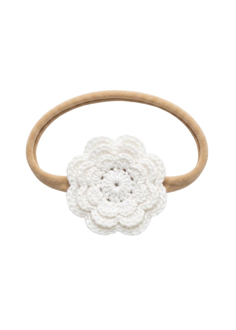 K&ouml;nnte beinhalten: Ein wei&szlig;es, geh&auml;keltes Blumenstirnband mit einem beigefarbenen Gummiband. Die Blume ist der Mittelpunkt und weist detaillierte Bl&uuml;tenbl&auml;tter auf. Geeignet f&uuml;r Babys und Kleinkinder.