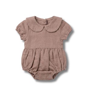 Puede incluir: Un pelele para beb&eacute; de color rosa empolvado, con cuello redondo y mangas cortas. El pelele presenta una cintura fruncida y cierres de presi&oacute;n en la parte inferior. Fabricado en tejido suave y texturizado, est&aacute; dise&ntilde;ado para la comodidad y el estilo.