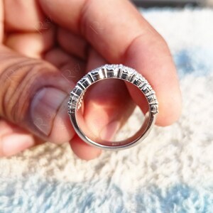 May include: A silver ring with a row of small, clear stones set in a band.