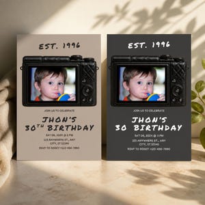 May include: Two rectangular birthday invitation cards featuring a camera graphic with a child's photo on the screen. Text reads: EST. 1996, JOIN US TO CELEBRATE, JHON'S 30TH BIRTHDAY, SAT 06, 202X @ 3 PM, 123 ANYWHERE ST., ANY CITY, ST 12345, RSVP TO ROSEY +123-456-7890.
