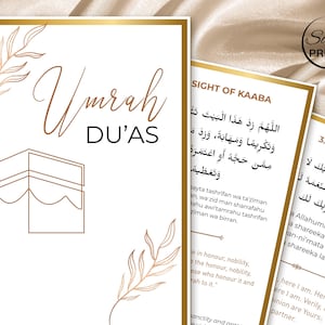 May include: White and gold Umrah Du'as cards with Arabic text and illustrations. The cards feature the text "Umrah DU'AS" in elegant script, along with a Kaaba illustration and floral accents. The Salam Prints logo is visible.