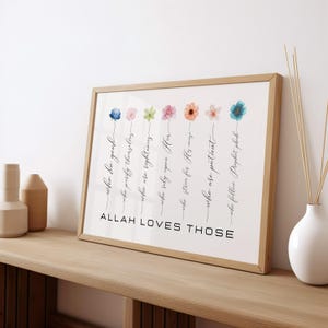 May include: A framed print with a white background and a black calligraphy quote that reads "ALLAH LOVES THOSE" with a list of qualities below. The list is decorated with colorful watercolor flowers.