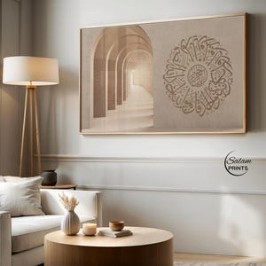 Puede incluir: Impresión enmarcada con una imagen sepia de un corredor arqueado y caligrafía árabe circular. La obra de arte se exhibe en un salón con una lámpara de pie y un sofá blanco.