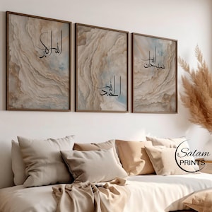 Puede incluir: Tres impresiones enmarcadas con un fondo de mármol beige y marrón. Las impresiones presentan caligrafía árabe en negro. Las impresiones están colgadas en una pared blanca sobre un sofá beige con almohadas.