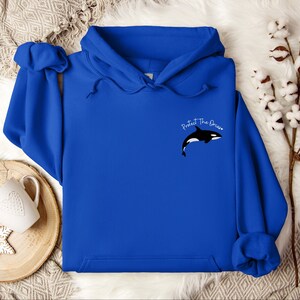 May include: A royal blue hoodie with a black and white orca graphic and the text "Protect The Ocean" in white.