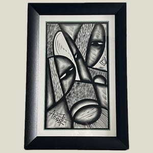 May include: Abstract black and white artwork in a black frame. The artwork features geometric shapes and stylized faces. The artist's signature is visible in the lower left corner. The artwork is framed with a white mount.