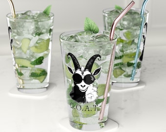 Könnte beinhalten: Drei klare Glasbecher mit Strohhalmen und Eis. Der Becher in der Mitte hat eine Schwarzweißillustration einer Ziege mit Sonnenbrille und dem Text "G.O.A.T."