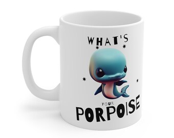 Könnte beinhalten: Weiße Keramiktasse mit einer schwarz-weißen Grafik eines Cartoon-Delfins und dem Text "What's your porpoise".