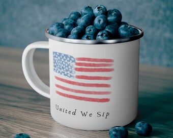 Könnte beinhalten: Weiße Email Tasse mit einem rot-weiß-blauen amerikanischen Flaggenmuster und dem Text "United We Sip". Die Tasse ist mit Blaubeeren gefüllt.