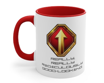 Könnte beinhalten: Eine weiße Keramiktasse mit rotem Rand und Henkel. Die Tasse zeigt eine goldene und rote Grafik eines nach oben zeigenden Pfeils in einem Sechseck mit dem Text "REALLY, REALLY RIDICULOUSLY GOOD-LOOKING".