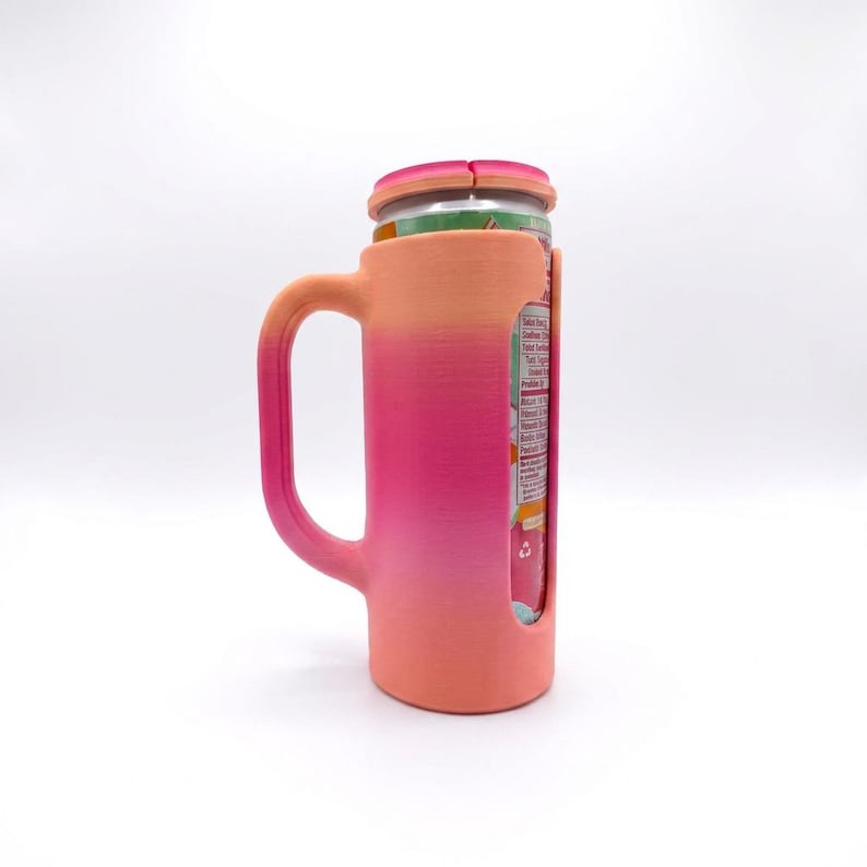 May include: A pink and orange gradient can cooler with a handle, designed to hold a beverage can. The cooler has a slot to view the can's label and a lid that fits over the top of the can.