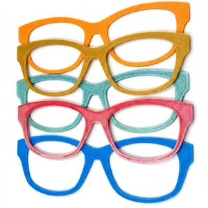May include: A stack of colorful eyeglass frames in orange, gold, teal, pink, and blue. The frames are arranged in a neat, overlapping pattern, showcasing a variety of vibrant colors. The frames are a classic, rectangular shape.