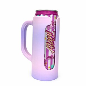 May include: A pink and purple ombre can cooler with a handle, holding a can of "Tutti Candy" energy drink. The can has a pink and white striped design with text. The cooler is designed to keep beverages cold.