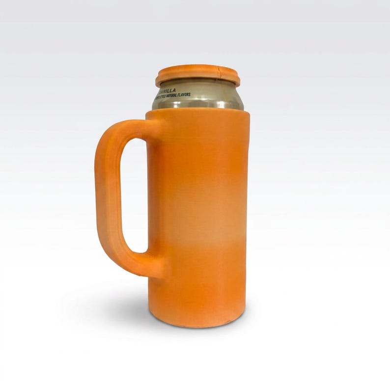 May include: Orange can cooler with a handle, designed to hold a standard-sized beverage can. The cooler has a cylindrical body and a curved handle for easy gripping. The top of the can is visible, with text that reads "Vanilla".