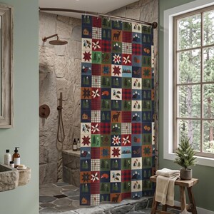 Könnte beinhalten: Ein Duschvorhang mit Patchwork-Gitterdesign, bestehend aus abwechselnden Quadraten mit rot-schwarzem Karomuster, Tannenbäumen, Bergen, Hirschen, Hütten und Sternenmustern in den Farben Dunkelrot, Waldgrün, Marineblau und Creme.