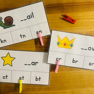 May include: Three printable cards with pictures of a snail, a star, and a crown. Each card has a word with a missing beginning sound and three options to choose from. The snail card says "--ail", the star card says "--ar", and the crown card says "--own".