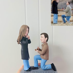 May include: A custom figurine depicting a marriage proposal scene. The male figure kneels, presenting a ring, while the female figure reacts with joy. The base reads "Today is the beginning of always."