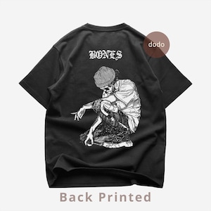 Könnte beinhalten: Schwarzes T-Shirt mit einer weißen Grafik eines Skeletts mit Mütze, das hockt. Das Wort "BONES" ist über der Grafik aufgedruckt. Der Text "Back Printed" befindet sich unten.