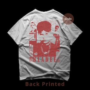 Puede incluir: Camiseta blanca con estampado gráfico rojo en la espalda. El diseño presenta un retrato, la palabra "BLADEE" en negrita y otros elementos gráficos. El texto "Back Printed" está en la parte inferior.
