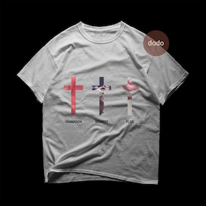 Puede incluir: Camiseta gris claro con tres cruces de diseños únicos. Las cruces son rojas, moradas y rosas. Las palabras OSAMASON, BIGGEST y FLXR están impresas debajo de cada cruz. La camiseta tiene cuello redondo.