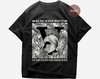 Puede incluir: Una camiseta negra de manga corta con un estampado gráfico de un casco espartano metálico centrado sobre una letra V grande. El texto "SUICIDEBOYS" aparece sobre el casco y "I NO LONGER FEAR THE RAZOR GUARDING MY HEEL" está impreso debajo.