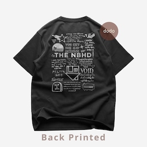May include: Black t-shirt with a white graphic design on the back. The design includes text, a house logo, and various illustrations. The text includes "THE NBHD", "VOID", and other phrases. The shirt is a casual wear item.